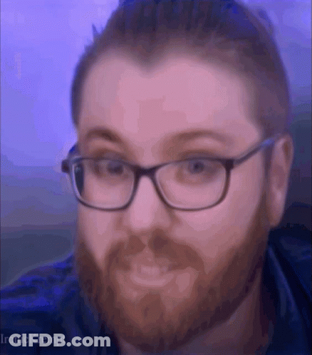 A Man With Glasses And A Beard Is Making A Face GIF