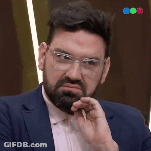 A Man With Glasses And A Beard Is Making A Funny Face GIF