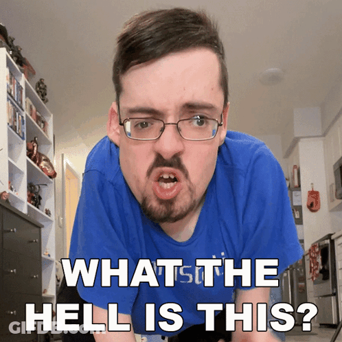 A Man With Glasses And A Beard Is Making A Funny Face And Says " What The Hell Is This " GIF