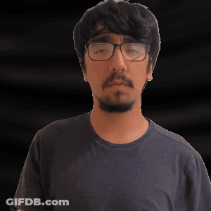 A Man With Glasses And A Beard Is Making A Gesture With His Hand GIF