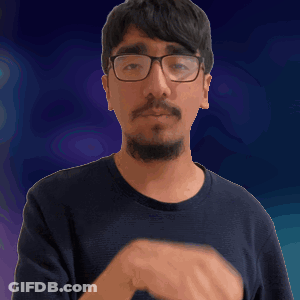 A Man With Glasses And A Beard Is Making A Silly Face GIF