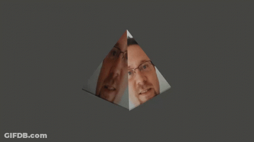 A Man With Glasses And A Beard Is Reflected In A Glass Pyramid GIF