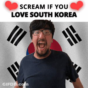 A Man With Glasses And A Beard Is Screaming In Front Of A Korean Flag GIF