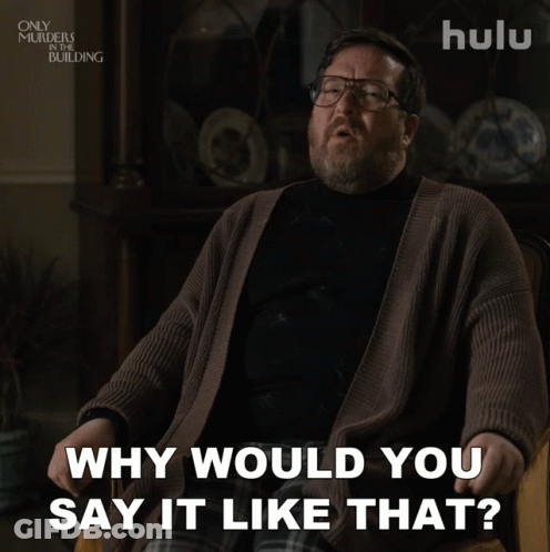 A Man With Glasses And A Beard Is Sitting In A Chair And Says " Why Would You Say It Like That " GIF