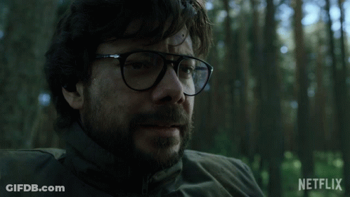 A Man With Glasses And A Beard Is Sitting In A Forest With A Netflix Logo In The Background GIF