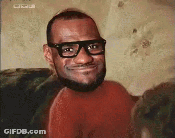 A Man With Glasses And A Beard Is Smiling For The Camera . GIF