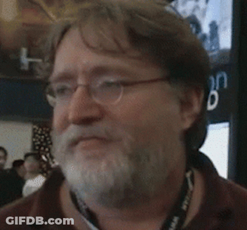 A Man With Glasses And A Beard Is Smiling In Front Of A Sign That Says " Vation Eiled " GIF
