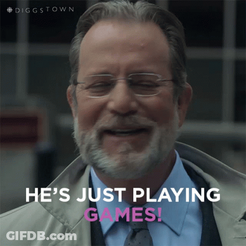 A Man With Glasses And A Beard Is Smiling With The Words He 'S Just Playing Games Below Him GIF
