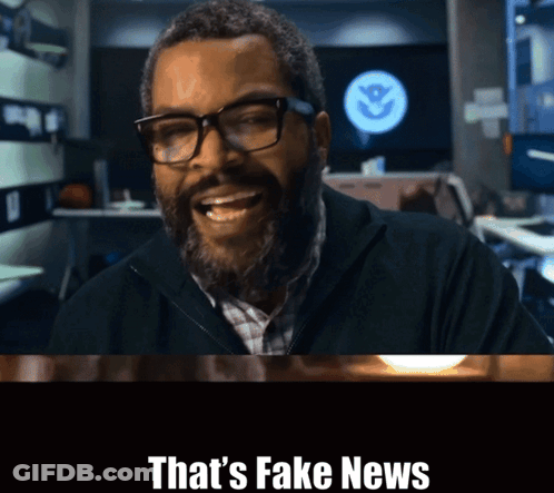 A Man With Glasses And A Beard Is Smiling With The Words That 'S Fake News Above Him GIF
