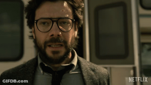 A Man With Glasses And A Beard Is Standing In Front Of A Netflix Logo GIF
