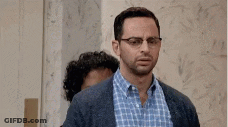 A Man With Glasses And A Beard Is Standing Next To Another Man With Glasses And A Beard . GIF