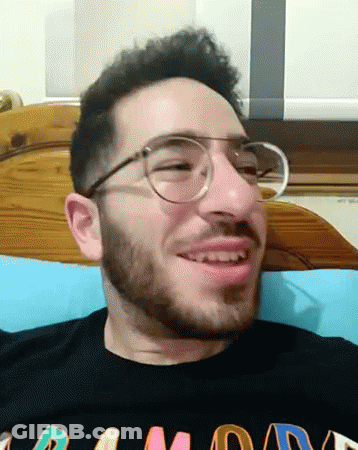 A Man With Glasses And A Beard Is Wearing A Black Shirt That Says Ramone GIF