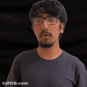 A Man With Glasses And A Beard Is Wearing A Gray Shirt GIF