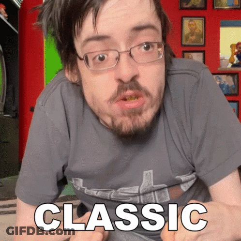 A Man With Glasses And A Beard Is Wearing A Grey Shirt That Says Classic GIF