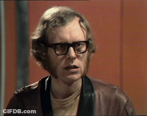 A Man With Glasses And A Beard Is Wearing A Leather Jacket GIF