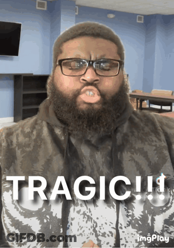 A Man With Glasses And A Beard Is Wearing A Shirt That Says Tragic On It GIF