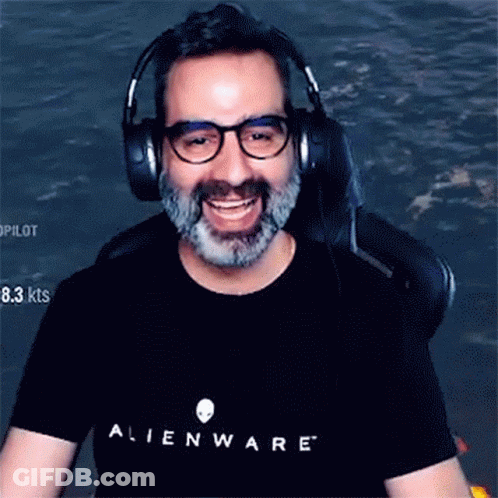 A Man With Glasses And A Beard Is Wearing Headphones And An Alienware Shirt GIF
