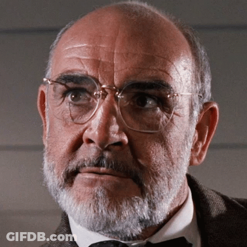 A Man With Glasses And A Beard Looks To His Left GIF