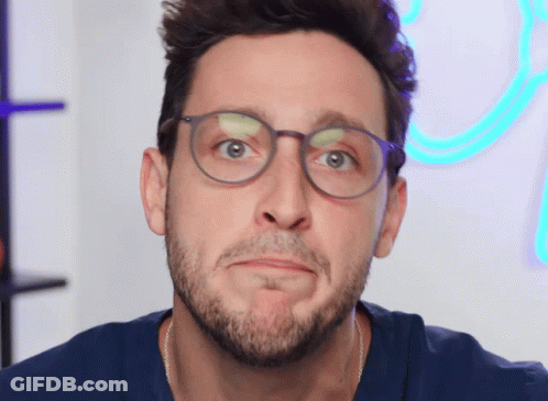 A Man With Glasses And A Beard Making A Face GIF