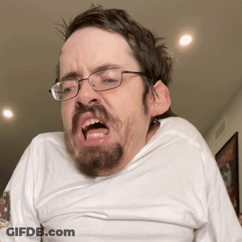 A Man With Glasses And A Beard Making A Face GIF