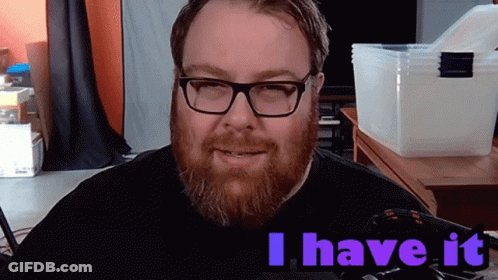 A Man With Glasses And A Beard Says " I Have It " In Purple Letters GIF