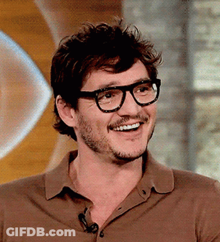 A Man With Glasses And A Beard Smiles For The Camera GIF