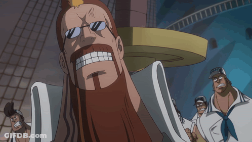 A Man With Glasses And A Beard Stands In Front Of A Sign That Says " G.o.t. " GIF