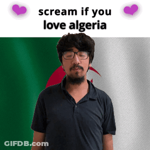 A Man With Glasses And A Beard Stands In Front Of An Algeria Flag And Says Scream If You Love Algeria GIF