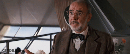 A Man With Glasses And A Bow Tie Is Talking To Someone GIF