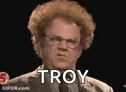 A Man With Glasses And A Curly Haircut Is Talking To Troy . GIF