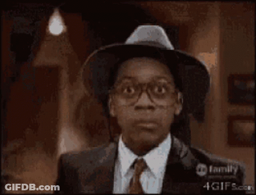 A Man With Glasses And A Hat Is Smiling GIF