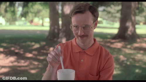 A Man With Glasses And A Mustache Is Holding A Spoon In A Cup GIF