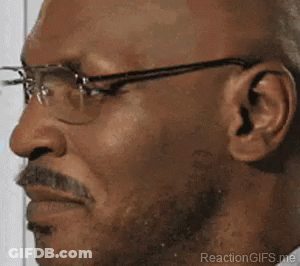 A Man With Glasses And A Mustache Is Making A Face . GIF