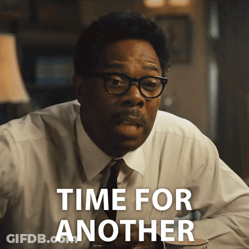 A Man With Glasses And A Mustache Is Sitting At A Table And Says Time For Another GIF