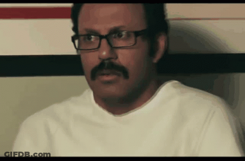 Man With Glasses And Mustache Sitting Down GIF