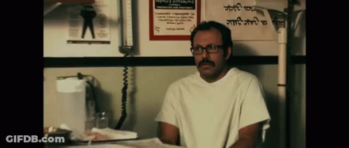 Man With Glasses And Mustache In Front Of Sign 'A GIF