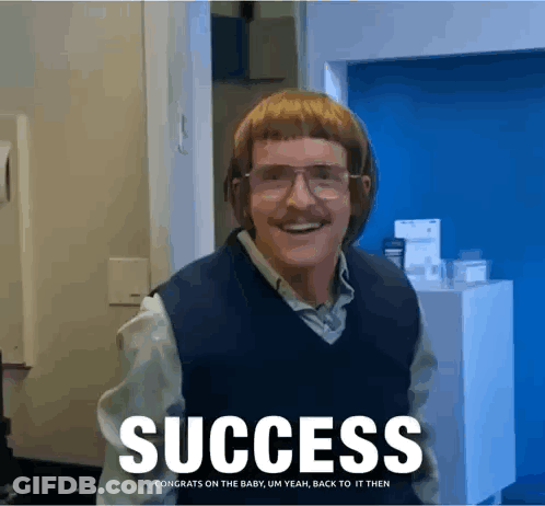 A Man With Glasses And A Mustache Is Standing In Front Of A Sign That Reads Success GIF