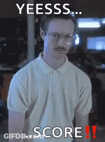 A Man With Glasses And A Mustache Is Standing In Front Of A Sign That Says Yeesss Score GIF