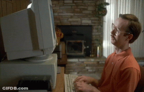 A Man With Glasses And A Mustache Is Typing On A Keyboard In Front Of A Computer Monitor GIF