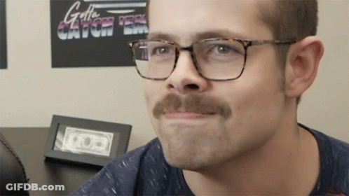 Man With Glasses And Mustache Looking At Camera GIF