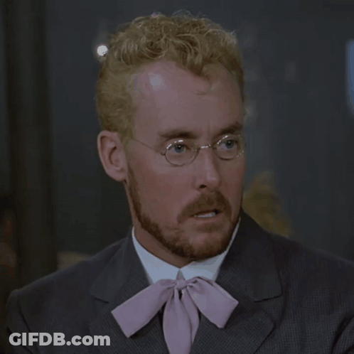 A Man With Glasses And A Pink Tie Looks Surprised GIF