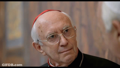 A Man With Glasses And A Red Hat Looks To The Side GIF