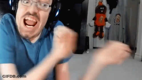 A Man With Glasses And A Reese 'S Candy Mascot Behind Him GIF