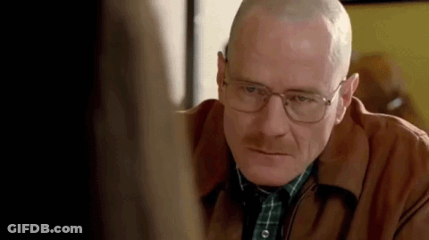A Man With Glasses And A Shaved Head Is Looking At A Woman . GIF