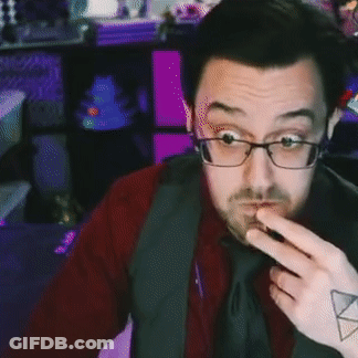 A Man With Glasses And A Tattoo On His Arm Is Pointing At Something . GIF