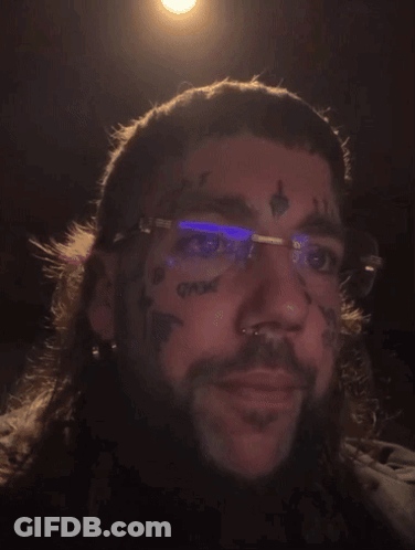 A Man With Glasses And A Tattoo On His Face GIF