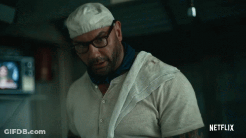 A Man With Glasses And A Towel Around His Neck Has A Netflix Logo On His Shirt GIF