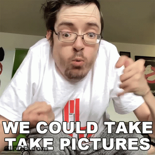 A Man With Glasses And A White Shirt That Says We Could Take Pictures On It GIF