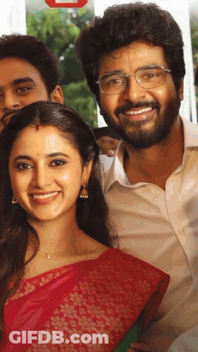 A Man With Glasses And A Woman In A Red Saree Smile For A Picture GIF