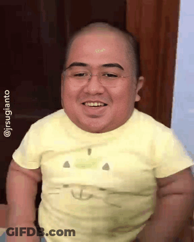 A Man With Glasses And A Yellow Shirt Is Smiling GIF